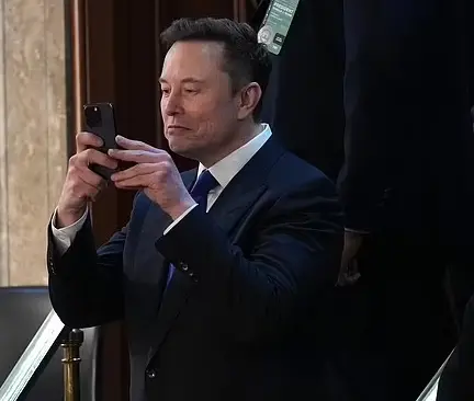 머스크가 드물게 정장 차림으로 국회에 나타났으나, 휴대폰 사용으로 경고를 받았다